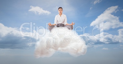 Digitally generated image of businesswoman meditating on cloud in sky