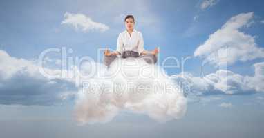 Digitally generated image of businesswoman meditating on cloud in sky