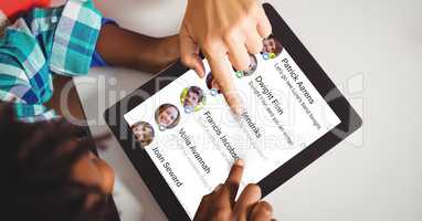 High angle view of hand touching chat list on tablet computer at table