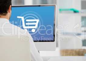 Person using computer with Shopping trolley icon