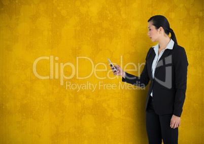Businesswoman holding phone with yellow grunge background