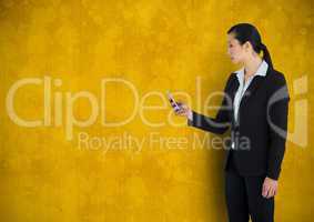 Businesswoman holding phone with yellow grunge background