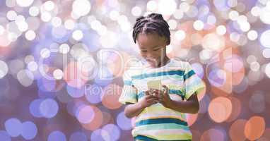 Happy boy using smart phone over bokeh