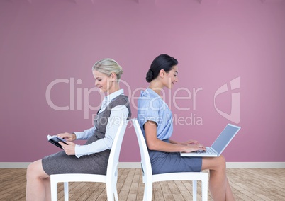 Businesswomen collaborating working back to back on chairs