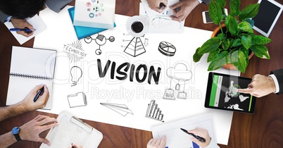 Vision text by icons and business people on table