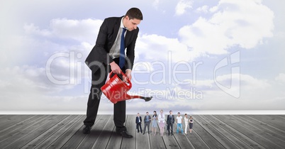 Digital composite image of businessman watering employees on boardwalk