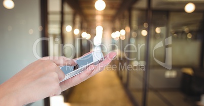 Hand touching blank screen of smart phone in office