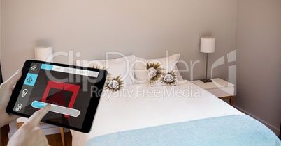 Hands using smart home application on digital tablet in bedroom