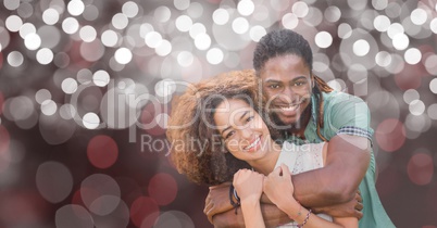 Happy man embracing woman over blur background