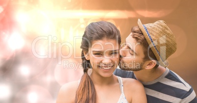 Man kissing happy woman over bokeh
