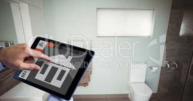 Hand using smart home app on tablet PC in washroom
