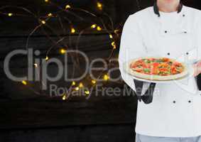 Chef with pizza. Wood and lights background