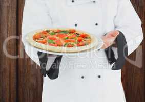 Chef showing the pizza. Wood background
