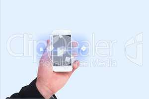 Digitally generated image of hand showing smart phone with various icons in background