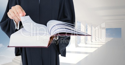 Midsection of judge holding law book