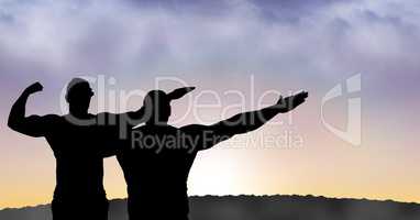 Silhouette men with arms raised during sunset