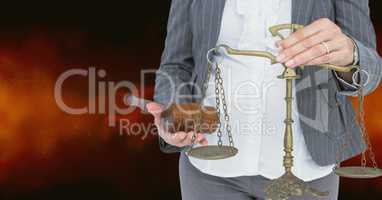 Midsection of judge holding law scales and hammer