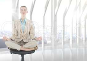 Business woman meditating on chair with flare against blurry white window