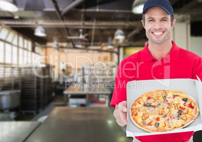Happy deliveryman showing the pizza in the kitchen