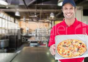Happy deliveryman showing the pizza in the kitchen