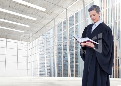 Judge holding book in front of large windows in city