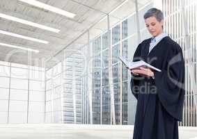 Judge holding book in front of large windows in city