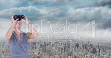 Digital composite image of businesswoman looking through binoculars with city in background