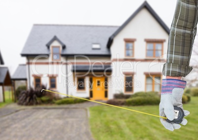 hand with meter in front of a real house