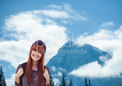 mountain travel, happy woman with purple hat in front of a mountain