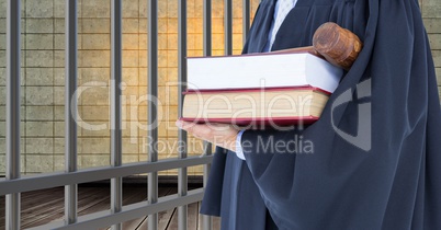 Midsection of judge with gavel and books