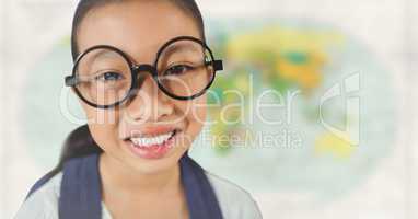 Girl with glasses smiling against blurry map