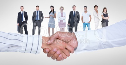 Business people shaking hands with colleagues in background