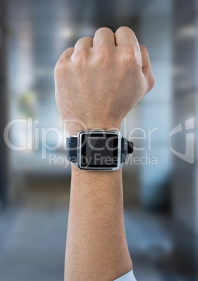 Fist in air with watch against blurry hallway