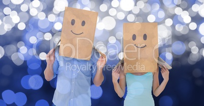 Couple with emojis on cardboard boxes over bokeh