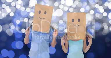 Couple with emojis on cardboard boxes over bokeh