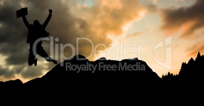 Silhouette businessman jumping on mountain during sunset