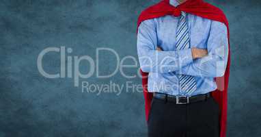 Business man superhero mid section with arms folded against blue background and grunge overlay