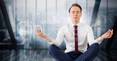 Business man meditating against dark blue blurry window