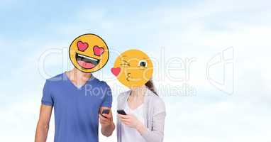 Couple with emojis over faces using mobile phones