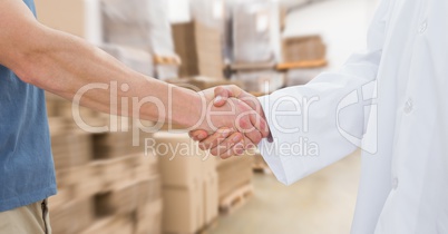 Midsection of man and doctor shaking hands in warehouse