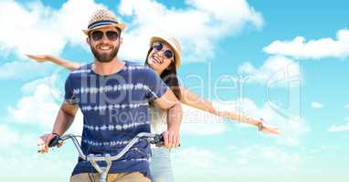 happy couple on bike against bright sky
