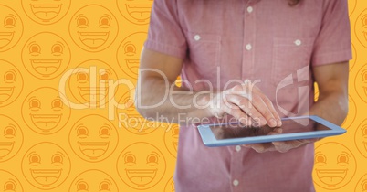 Man pink shirt mid section with tablet against yellow emoji pattern