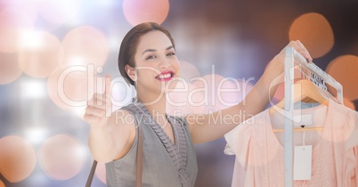 Happy woman showing thumbs up while shopping over bokeh