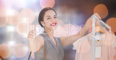 Happy woman showing thumbs up while shopping over bokeh