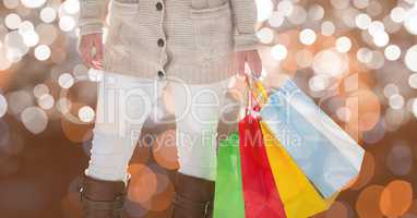 Midsection of woman holding colorful shopping bags