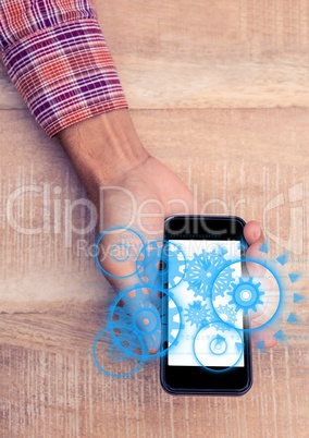Overhead of hand with phone showing blue cog graphics with flare