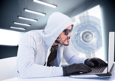 Criminal in hood on laptop in front of interface