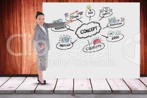 Businesswoman gesturing on billboard with various icons while standing in office