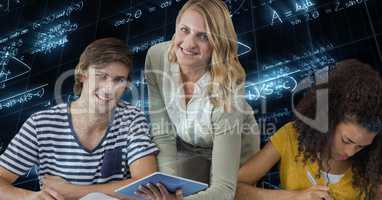 Female teacher holding tablet PC by students against math equations