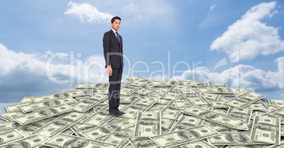 Digital composite image of businessman standing on money against sky